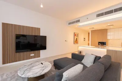 a living room with a couch and a table and a tv at Boutique 2BDR Ellington House, Dubai Hills in Dubai