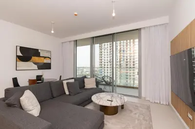 a living room with a gray couch and a large window at Boutique 2BDR Ellington House, Dubai Hills in Dubai