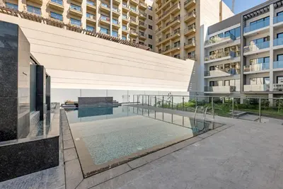 a swimming pool in the middle of a building at Waves - Modern Comfort in JVC - Elegant 1BR Stay in Dubai
