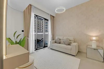 a white living room with a couch and a window at Waves - Modern Comfort in JVC - Elegant 1BR Stay in Dubai