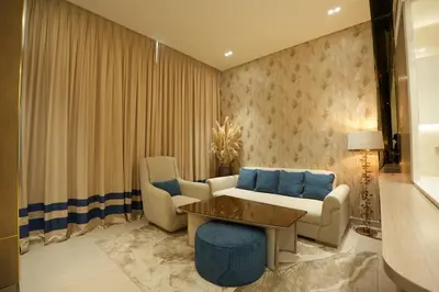 a living room with a couch and a table and chairs at OLD The Royal Blue Jacuzzi Suite 3501 in Dubai