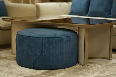 a coffee table with a blue ottoman under a table at OLD The Royal Blue Jacuzzi Suite 3501 in Dubai