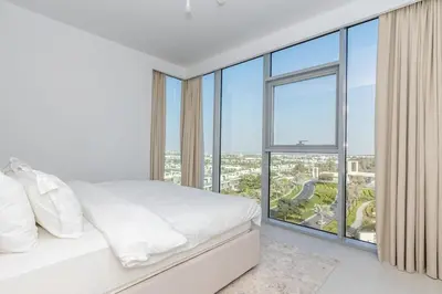 a bedroom with a white bed and a large window at Luxury 3BDR Ellington House Dubai Hills in Dubai