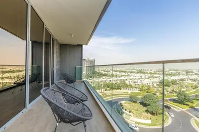 a balcony with two chairs and a view of a city at Luxury 3BDR Ellington House Dubai Hills in Dubai