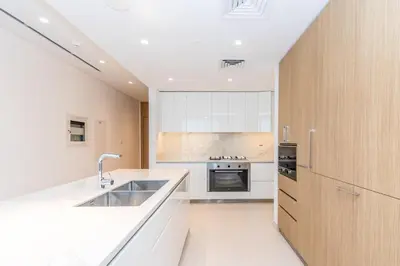 a kitchen with white cabinets and a sink and a stove at Luxury 3BDR Ellington House Dubai Hills in Dubai