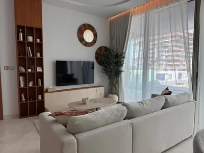 a living room with a white couch and a large window at 1 BR apartment in Ellington Beach House in Dubai