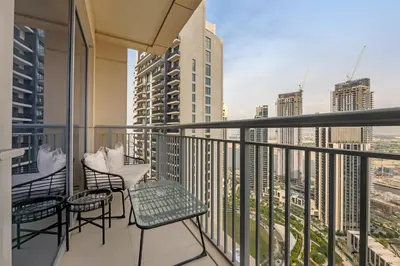 a balcony with chairs and a view of a city at Neat 3BR Habour Views with Balcony-Burj Khalifa View, Pool, Gym and Modern Facilities in Dubai