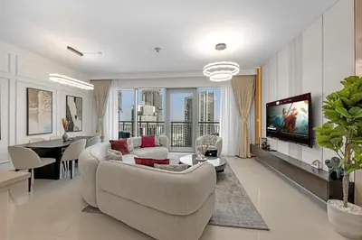 a living room with a couch and a table and a tv at Neat 3BR Habour Views with Balcony-Burj Khalifa View, Pool, Gym and Modern Facilities in Dubai