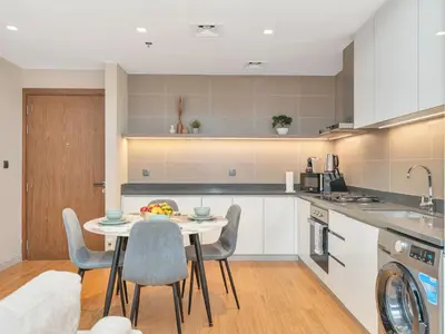a kitchen with a table with a bowl of fruit on it at Livora Stays - Dubai Marina With Balcony & Water Views in Dubai