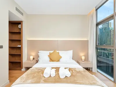 a bedroom with a bed with two white shoes on it at Livora Stays - Dubai Marina With Balcony & Water Views in Dubai