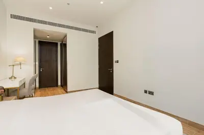 a bedroom with a white bed and a desk at CitiHome - Stunning 5-Star Suite Jumeirah Living in Dubai