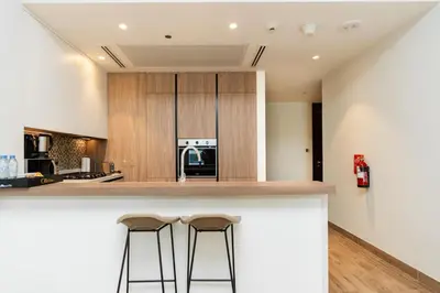 a kitchen with two bar stools at a counter at CitiHome - Stunning 5-Star Suite Jumeirah Living in Dubai
