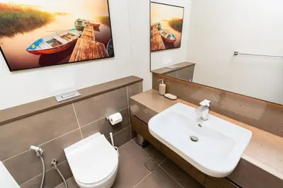 a bathroom with a sink and a toilet and a mirror at CitiHome - Stunning 5-Star Suite Jumeirah Living in Dubai
