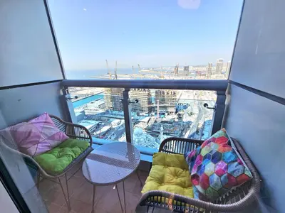 a balcony with chairs and a table and a view at Newly Upgraded 3-BR close to Barasti Beach in Dubai