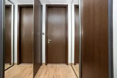 a row of wooden doors in a hallway at CitiHome - Elegant Retreat in Dubai Marinas Heart in Dubai