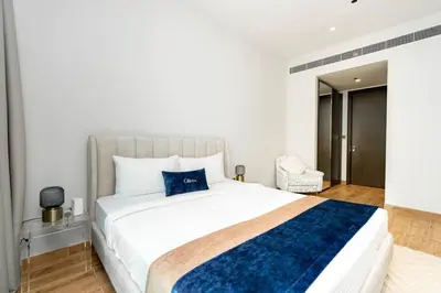 a bedroom with a large white bed with a blue blanket at CitiHome - Elegant Retreat in Dubai Marinas Heart in Dubai