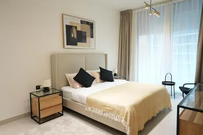 a bedroom with a bed and a table and a window at 2BR Luxury, 2,5 bath, Baby bed, Gym & Pool in Dubai