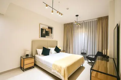 a hotel room with a bed and a desk at 2BR Luxury, 2,5 bath, Baby bed, Gym & Pool in Dubai