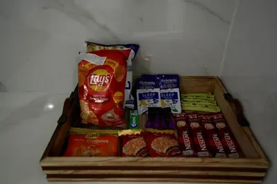 a wooden tray filled with different types of snacks at 2BR Luxury, 2,5 bath, Baby bed, Gym & Pool in Dubai