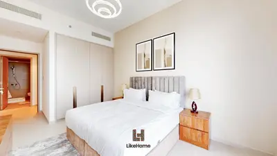 a white bedroom with a large bed and a table at Direct Burj Khalifa views Lux Sky Manson Like Home in Dubai