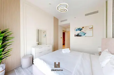 a white bedroom with a bed and a mirror at BEST BURJ VIEW IN DUBAI DOWNTOWN 2BR in Dubai