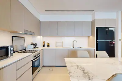 a kitchen with white cabinets and a black refrigerator at NEXT TO DUBAI MALL AND BURJ 2 BR SEA VIEW in Dubai