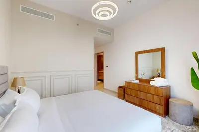 a white bedroom with a bed and a mirror at NEXT TO DUBAI MALL AND BURJ 2 BR SEA VIEW in Dubai