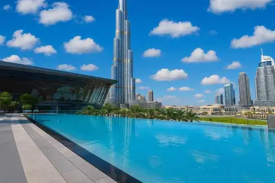 a large swimming pool in front of a city skyline at 5 MINUTES BY WALK FROM BURJ ADN DUBAI MALL in Dubai