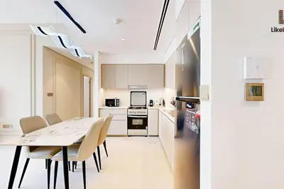 a kitchen with a table and chairs and a refrigerator at 5 MINUTES BY WALK FROM BURJ ADN DUBAI MALL in Dubai