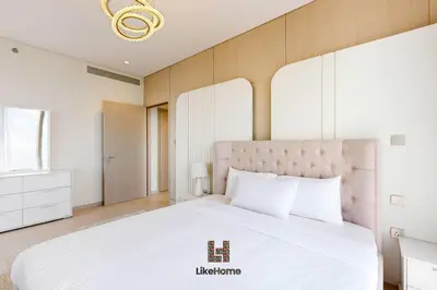 a bedroom with a white bed and a chandelier at NEXT TO BURJ KHALIFA AND DUBAI MALL in Dubai