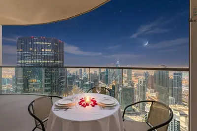 a table with a candle on a balcony with a city skyline at NEXT TO BURJ KHALIFA AND DUBAI MALL in Dubai