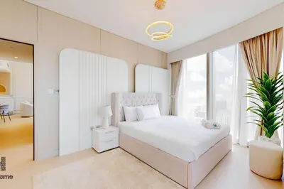 a bedroom with a white bed and a large window at NEXT TO BURJ KHALIFA AND DUBAI MALL in Dubai