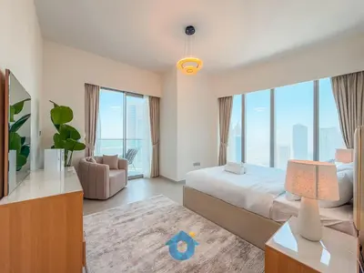 a bedroom with a bed and a couch and windows at Best Burj Khalifa Skyline View Huge 3BR Like Home in Dubai