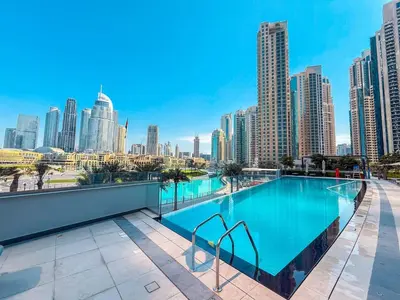 a swimming pool on the roof of a building with a city skyline at Direct Burj Khalifa View Near Dubai Mall Like Home in Dubai