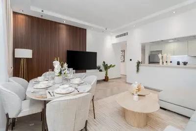 a white living room with a table and chairs at Gala Guests - Signature Skyview Tower High-Floor Marina Living in Dubai