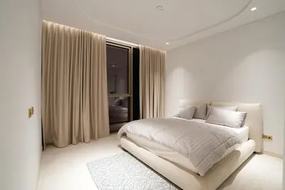 a white bedroom with a bed and a window at Spacious 2BR Near Beach Ellington in Dubai
