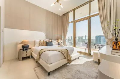 a white bedroom with a bed and a chair at Community View, Near the Circle Mall, Pear House II by Imtiaz, Jumeirah Village Circle by Deluxe Holiday Homes in Dubai
