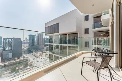 a balcony with a table and chair and a view of the city at Community View, Near the Circle Mall, Pear House II by Imtiaz, Jumeirah Village Circle by Deluxe Holiday Homes in Dubai