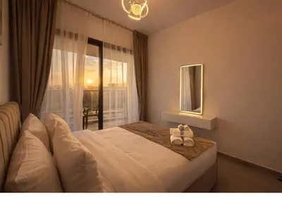 a hotel room with a bed and a window at Stylish & Cozy 2BR Apartment in Liwan 2 in Dubai