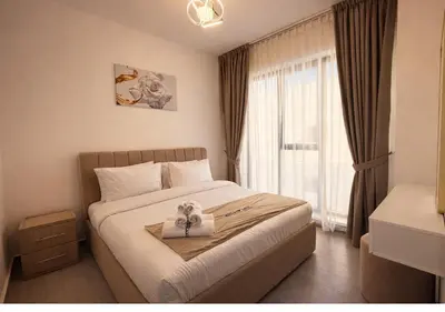 a bedroom with a bed with a tray with a bow on it at Stylish & Cozy 2BR Apartment in Liwan 2 in Dubai