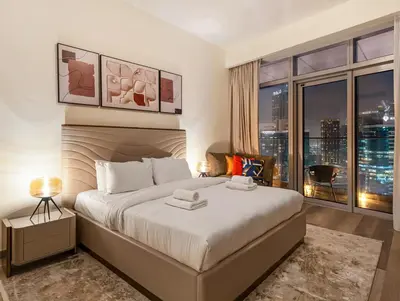 a bedroom with a large bed and a large window at Luxurious 3-bedroom apartment downtown in Dubai
