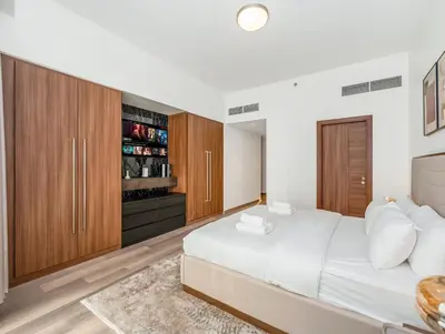 a bedroom with a large white bed and wooden cabinets at Luxurious 3-bedroom apartment downtown in Dubai