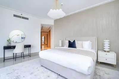 a white bedroom with a white bed and a desk at Vogue Downtown Opera Grand near Burj Khalifa and Dubai Mall, Two Bedroom Apartment with Large Balcony and Access to all Amenities in Dubai