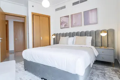 a bedroom with a large bed with white sheets at Vogue Downtown Opera Grand near Burj Khalifa and Dubai Mall, Two Bedroom Apartment with Large Balcony and Access to all Amenities in Dubai
