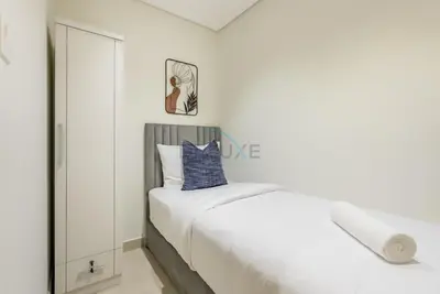 a white bedroom with a bed and a mirror at Balcony-Facing Pool 2BR with Assistant Room, Minutes Walk to Park, Miracle and Butterfly Garden, Divine Living, Arjan by Deluxe Holiday Homes in Dubai