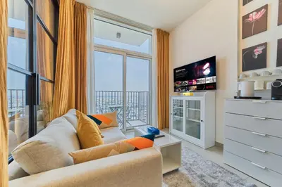 a living room with a couch and a large window at Chic & Modern 1BR Stay in Collective Dubai Hills in Dubai