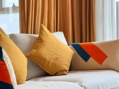 a couch with pillows on top of it at Chic & Modern 1BR Stay in Collective Dubai Hills in Dubai