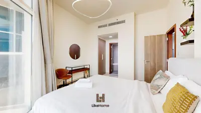 a hotel room with a bed and a desk at Family-Friendly 2BR in Azizi Plaza with Pool & Gym in Dubai