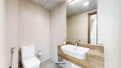a bathroom with a sink and a toilet and a mirror at Family-Friendly 2BR in Azizi Plaza with Pool & Gym in Dubai