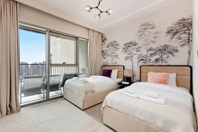 a bedroom with two beds and a large window at Luxury 2BR Downtown Steps from Burj Khalifa in Dubai